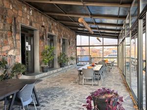 an outdoor patio with tables and chairs and windows at NorDar in Garni