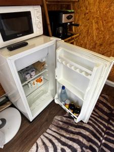 a refrigerator with its door open next to a microwave at Ô Balcon in Sainte-Rose +10 photos