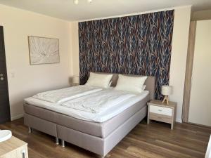 a bed in a bedroom with a wall mural at Gästehaus Eifelzauber in Kelberg