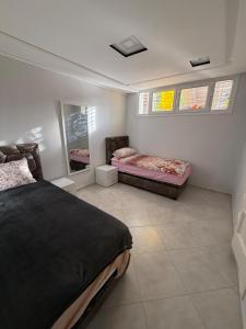 a bedroom with two beds and two windows at Exceptional Villa Pool in Oujda +16 photos
