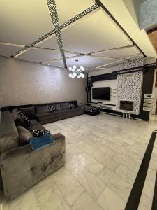 a living room with a couch and a television at Exceptional Villa Pool in Oujda
