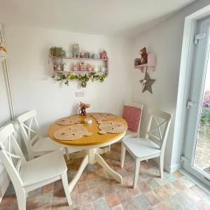 a dining room with a wooden table and chairs at Bear Cottage - Waterfall Country in Glyn Neath