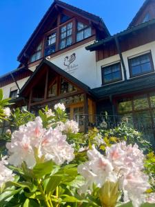a building with a bunch of flowers in front of it at Goldener Hahn Ferienwohnungen Pool, Sauna & Frühstücksservice in Baiersbronn