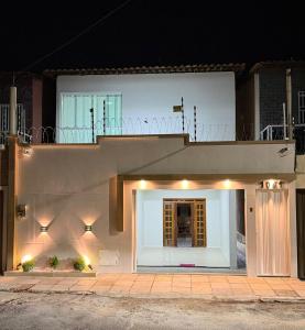 a white house with a balcony on top of it at CS2 - Ampla - Suítes e Ar-Cond em Todos os Quartos in Juazeiro do Norte