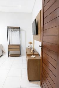 a door in a room with a desk and a mirror at CS2 - Ampla - Suítes e Ar-Cond em Todos os Quartos in Juazeiro do Norte