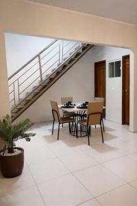 a dining room with a table and chairs and a staircase at CS2 - Ampla - Suítes e Ar-Cond em Todos os Quartos in Juazeiro do Norte
