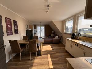 a kitchen and living room with a table and a couch at Gästehaus Eifelzauber in Kelberg