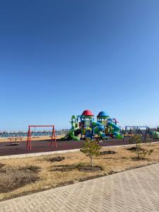 a park with a playground with a water slide at Коттедж Alfa in Koshkolʼ