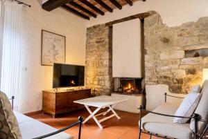 ein Wohnzimmer mit Fernseher und Kamin in der Unterkunft Frascole in Dicomano