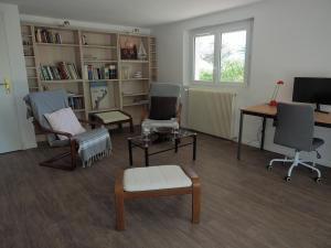 a living room with chairs and a table and a desk at Renovated villa by the ocean in Barbâtre