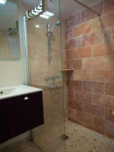a bathroom with a glass shower with a sink at Renovated villa by the ocean in Barbâtre +13 photos