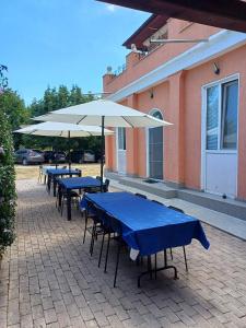 a group of tables with umbrellas in front of a building at Vila Puskin - Eforie Sud in Eforie Sud