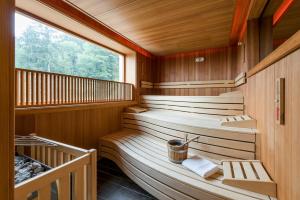 a sauna with two benches and a large window at Berghaus - Der Westerhof Hotel in Tegernsee +45 photos
