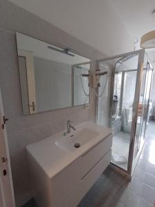 a white bathroom with a sink and a mirror at UN BEL POSTO AL MARE in Savona