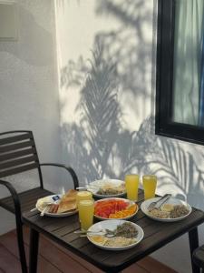 a table with plates of food and glasses of orange juice at Luma Boutique Hotel Omadhoo in Omadhoo +15 photos