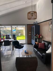a living room with a couch and a table at Luxe vakantiehuis met omheinde tuin voor hond en kinderen in Dirkshorn