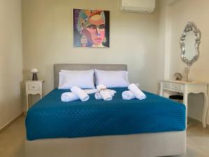a bedroom with a blue bed with two teddy bears on it at Aristos Apartments & Suites in Stalos