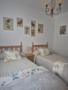 a bedroom with two beds and a table with a lamp at Casa La Candela in Montemayor del Río