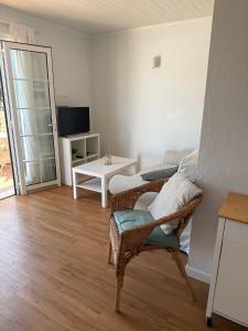 a living room with a chair and a table at Apartamento Cala En Bosch B10 in Cala en Bosc