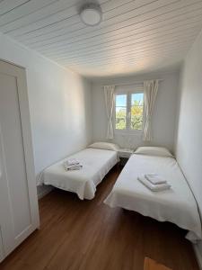 two beds in a white room with a window at Apartamento Cala En Bosch B10 in Cala en Bosc +7 photos