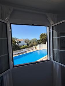 a view of a swimming pool through a window at Apartamento Cala En Bosch B10 in Cala en Bosc