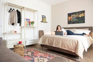 a woman laying on a bed with a laptop at Casa Pulverun in Domodossola