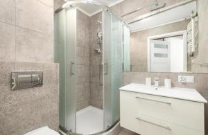 a bathroom with a shower and a toilet and a sink at M-Apartamenty in Kołobrzeg +75 photos