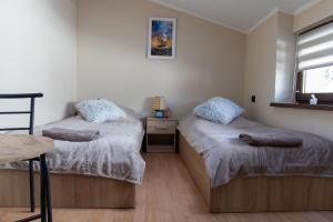 two twin beds in a room with a window at U Marysi i Jerzego in Żarnowska