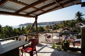 a balcony with a table and chairs and a view of the ocean at TerraZica hostal in Brisas de Zicatela