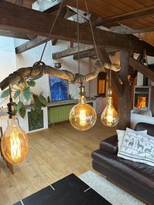 a living room with several lights hanging from the ceiling at BLUELAND Loft in Hechendorf