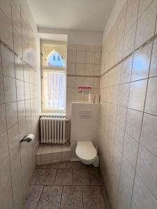 a small bathroom with a toilet and a window at Haus St Vinzenz in Berlin