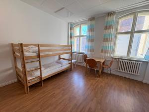 a bedroom with a bunk bed and a table and chairs at Haus St Vinzenz in Berlin