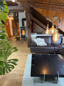 a living room with a leather couch and a fireplace at BLUELAND Loft in Hechendorf