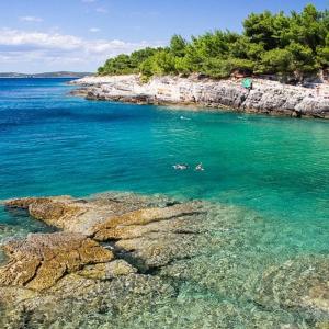 a group of people swimming in a body of water at El Dorado in Premantura