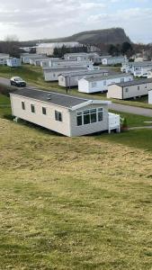 a small white building in a field of grass at JSNHolidays at Craig Tara Holiday Park in Ayr +21 photos