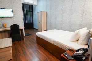 a room with a bed and a desk and a television at CROWN REGENCY- BADULLA in Badulla