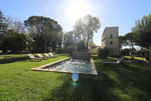 a park with benches and a fountain in the grass at Mas Volver Camargue in Arles