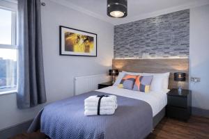 a bedroom with a bed and a brick wall at The Bromley's in Great Yarmouth