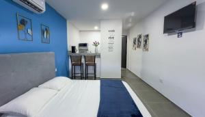 a bedroom with a bed with a blue wall at X Mahaná Apartamentos Temáticos in Mérida
