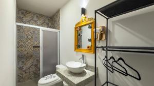 a bathroom with a sink and a toilet and a mirror at X Mahaná Apartamentos Temáticos in Mérida +93 photos