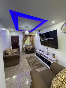 a living room with a couch and a flat screen tv at 3 Bedroom Flat Short Let in Iseri