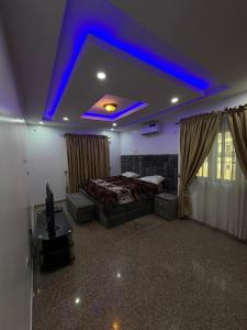 a bedroom with a bed and a blue lighting at 3 Bedroom Flat Short Let in Iseri +6 photos