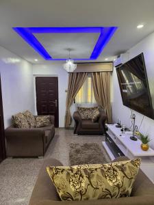 a living room with blue lights on the ceiling at 3 Bedroom Flat Short Let in Iseri