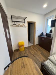 a living room with a table and a kitchen at Beregi Apartman in Tiszaújváros