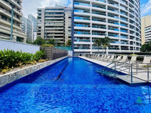 a large swimming pool with chairs in front of a building at My Way by Holiday Stays in Fortaleza
