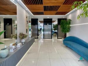 a lobby with a blue couch and books at My Way by Holiday Stays in Fortaleza +32 photos
