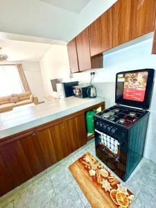 a kitchen with a stove and a cutting board with food at brigit's home in Kisumu