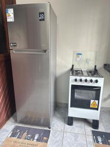 a refrigerator and a stove in a kitchen at Apartamento Barbosa in Santarém +1 photo