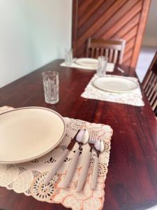 a wooden table with plates and utensils on it at Apartamento Barbosa in Santarém
