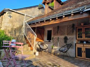 a group of chairs sitting on a deck next to a house at La parenthèse bucolique in Sepmes